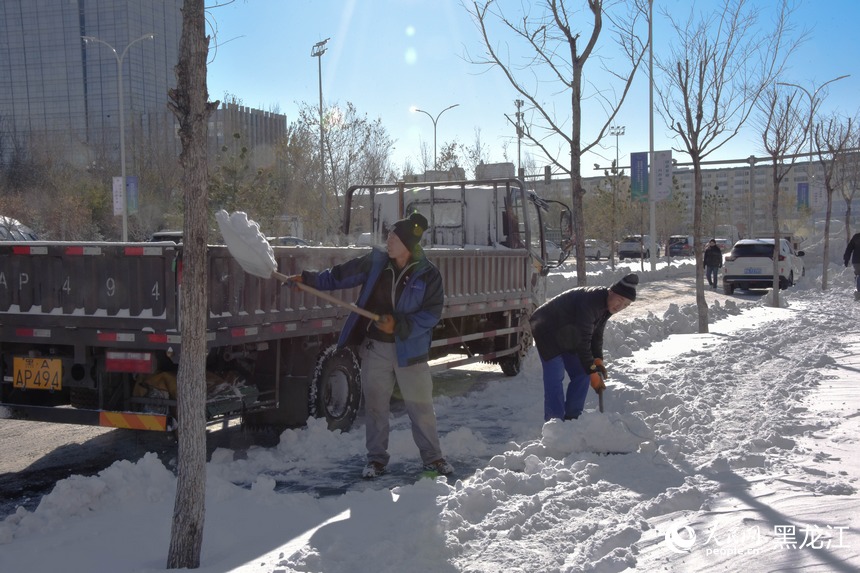 工人正在將雪裝車。人民網 徐成龍攝