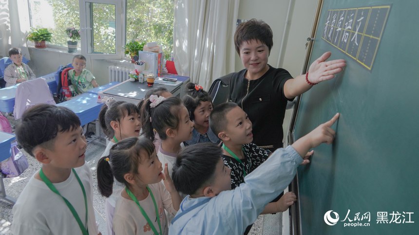 哈爾濱市繼紅小學哈西校區，老師帶領學生讀黑板上的板書。人民網 徐成龍攝