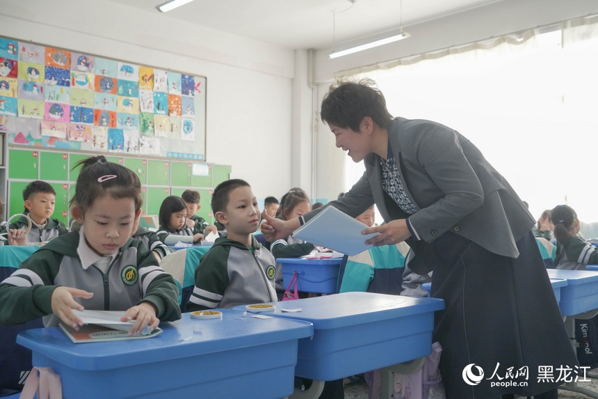 哈爾濱市繼紅小學(xué)校老師在開學(xué)第一天的課堂上給學(xué)生點(diǎn)贊。人民網(wǎng) 徐成龍攝