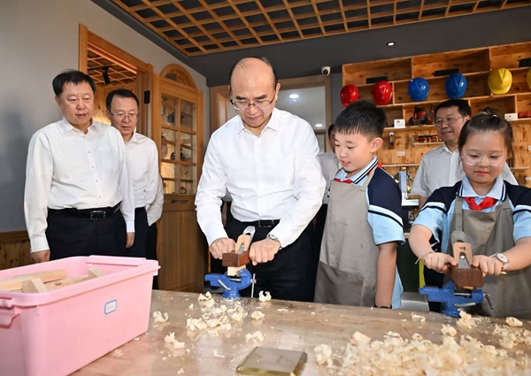 在花園小學校勞動實踐課堂上，許勤與孩子們一起動手操作。