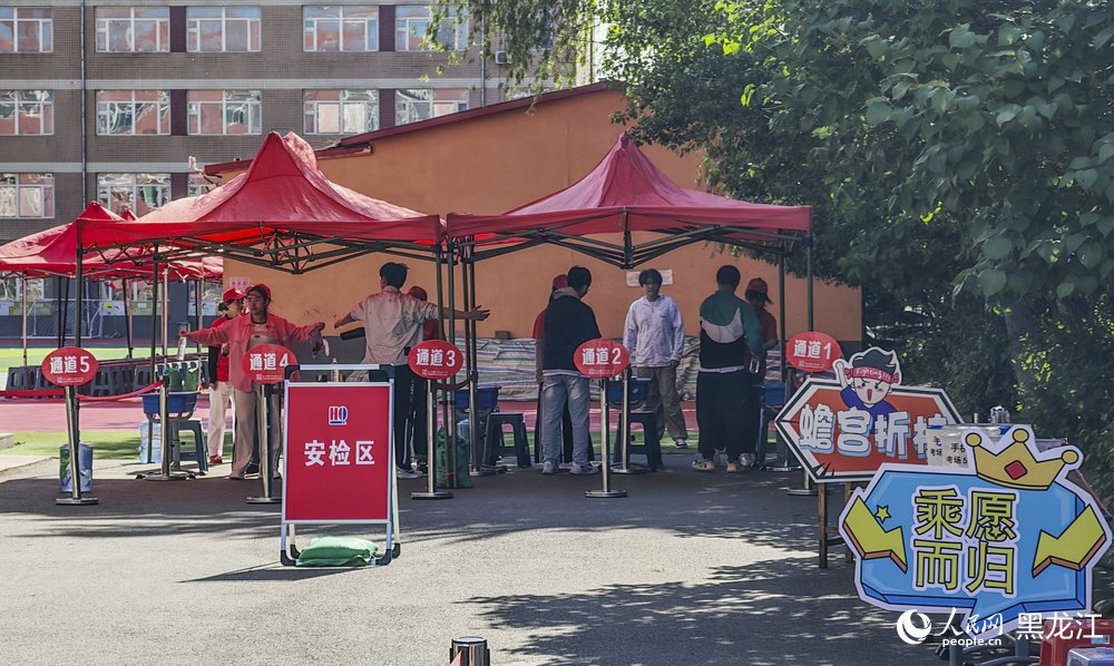 哈爾濱市虹橋第二小學(xué)考場(chǎng)外，考生們?cè)诮邮馨矙z。人民網(wǎng)記者 張哲鑫攝
